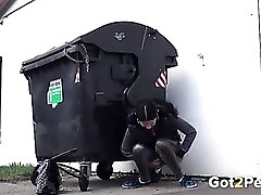 Shiny leggings girl pees behind a dumpster